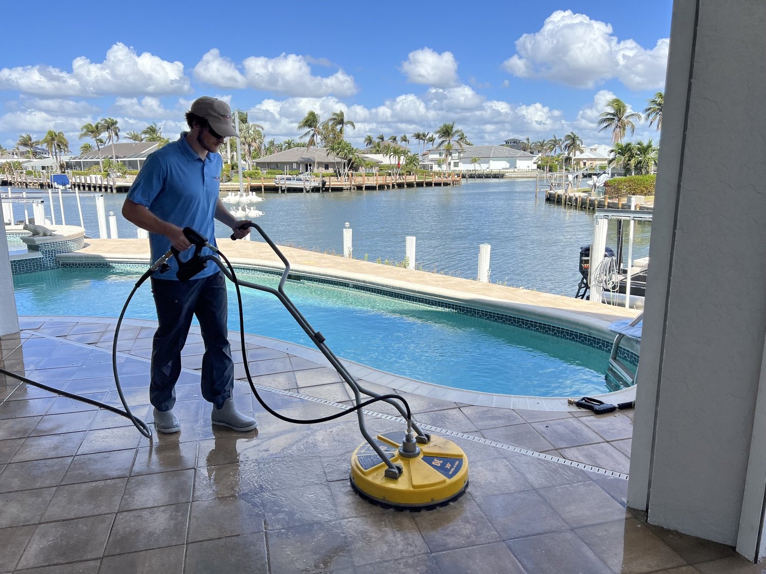 Coastal Rinse technician cleaning a waterfront pool deck in Naples