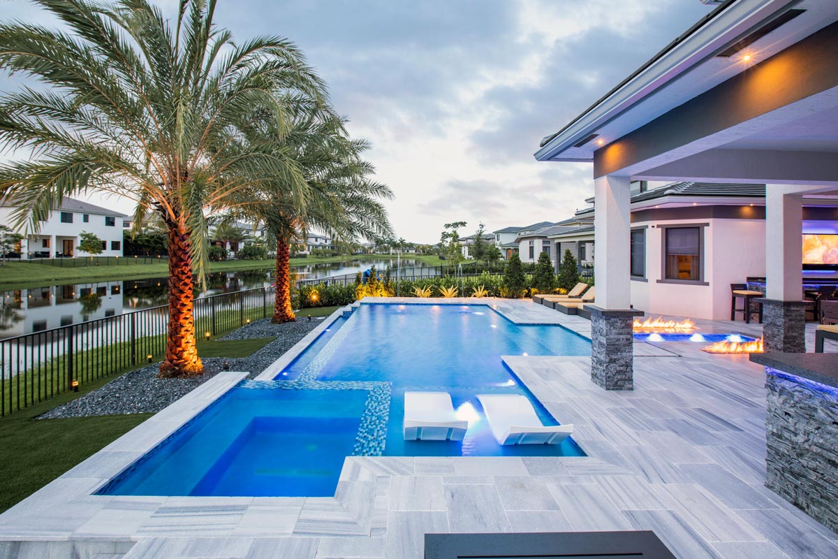 Modern Naples pool with palm trees and waterfront views at twilight